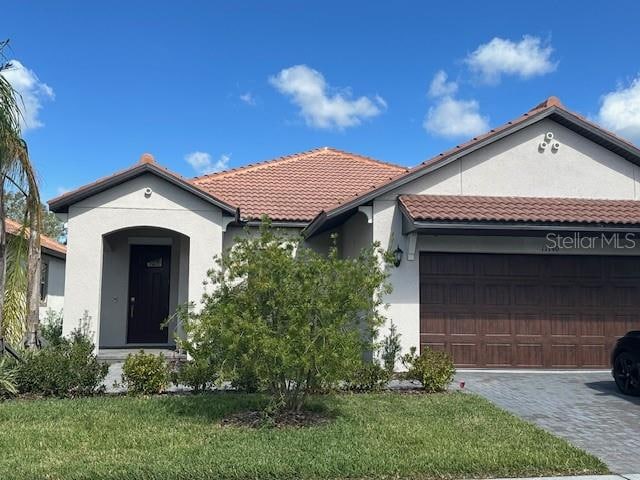 view of front of property with a garage and a front lawn