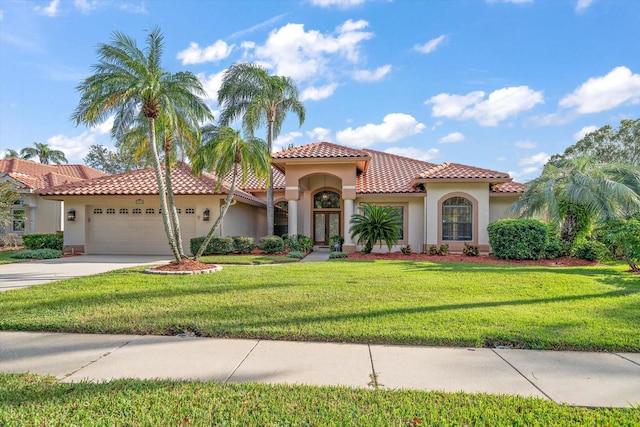 mediterranean / spanish home with a garage and a front lawn