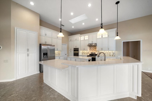 kitchen featuring a spacious island, white cabinetry, a skylight, decorative light fixtures, and stainless steel appliances