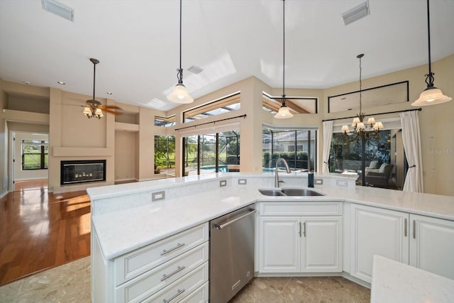 kitchen with white cabinetry, stainless steel dishwasher, sink, and decorative light fixtures