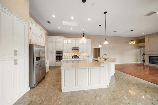 kitchen featuring a large island, white cabinetry, hanging light fixtures, and stainless steel appliances