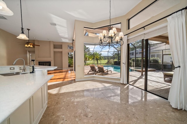 dining room featuring sink and ceiling fan with notable chandelier