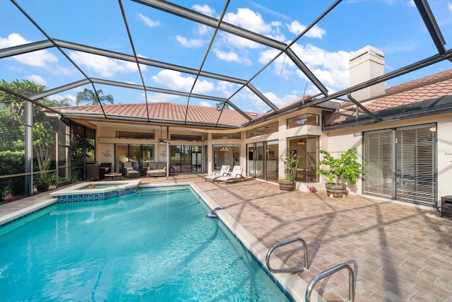 view of swimming pool with a patio, ceiling fan, a lanai, and an in ground hot tub