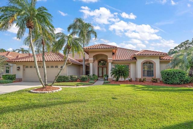 mediterranean / spanish-style house featuring a garage and a front lawn