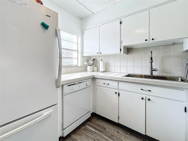 kitchen with white appliances, sink, decorative backsplash, dark hardwood / wood-style flooring, and white cabinetry