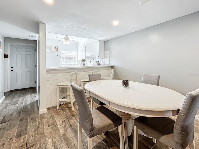 dining area with ceiling fan, sink, and light hardwood / wood-style flooring