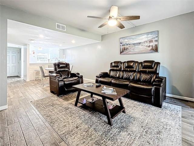 living room with ceiling fan and light wood-type flooring