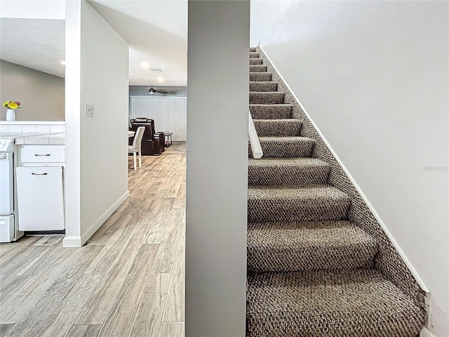 stairs with ceiling fan and wood-type flooring