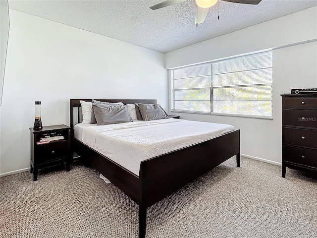 bedroom featuring ceiling fan, light carpet, and a textured ceiling