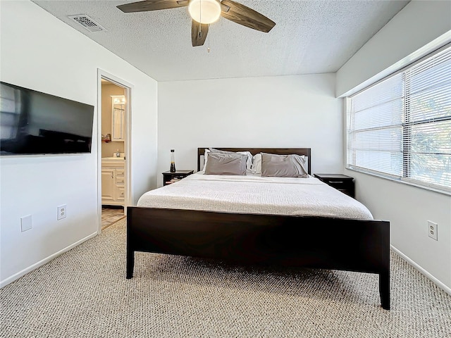 bedroom with carpet, ensuite bathroom, a textured ceiling, ceiling fan, and sink