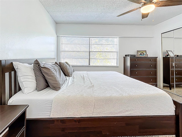 bedroom featuring ceiling fan, a closet, and a textured ceiling