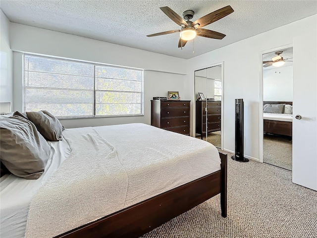 carpeted bedroom with ceiling fan and a textured ceiling