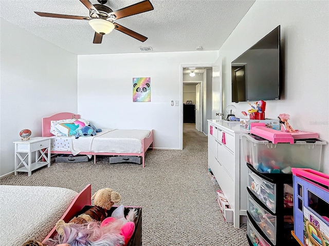 carpeted bedroom with a textured ceiling and ceiling fan