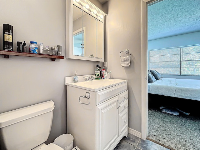 bathroom featuring tile patterned flooring, a textured ceiling, vanity, and toilet