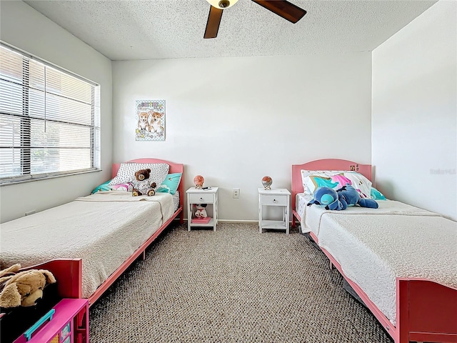 carpeted bedroom with ceiling fan and a textured ceiling