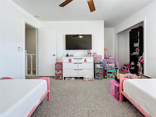 bedroom with carpet flooring, ceiling fan, and a textured ceiling