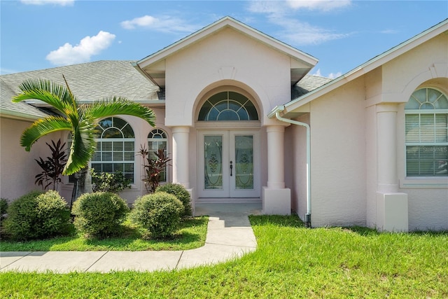 doorway to property featuring french doors and a lawn