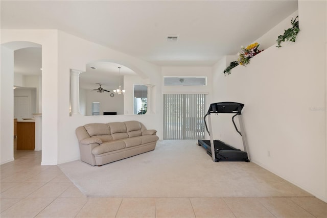 workout area with an inviting chandelier and light tile patterned floors