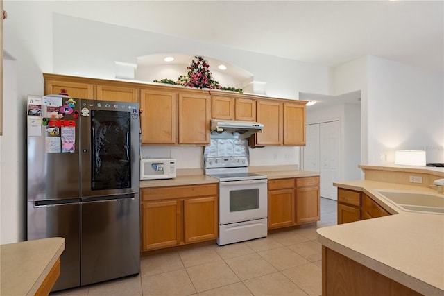 2152 SE Harding St, Port Saint Lucie, FL 34952 - kitchen featuring white appliances, a sink, under cabinet range hood, light tile patterned floors, and light countertops