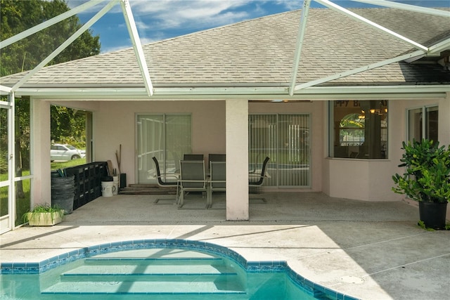 rear view of property featuring a patio area and glass enclosure