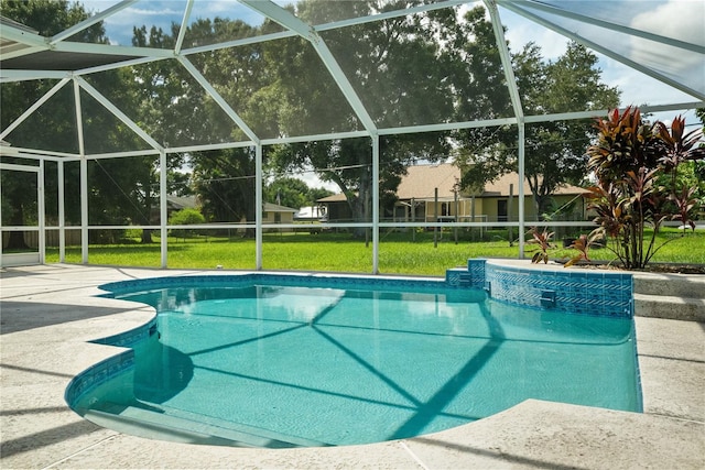 view of swimming pool with a patio, a yard, and glass enclosure