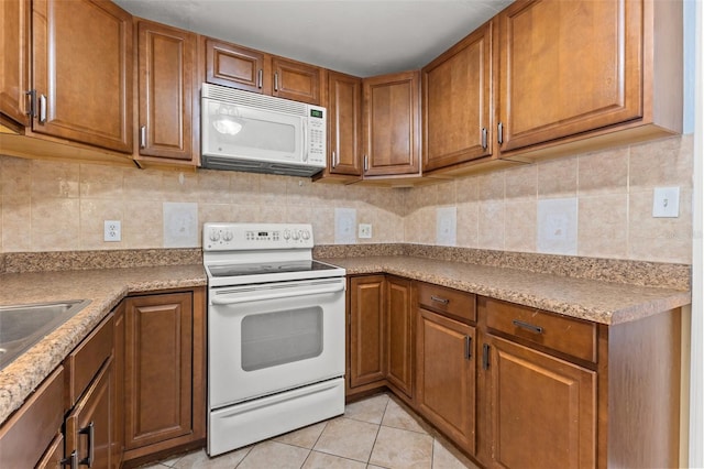 kitchen featuring sink, light tile patterned floors, white appliances, and decorative backsplash