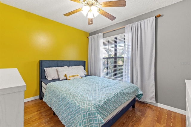 bedroom featuring hardwood / wood-style floors, a textured ceiling, and ceiling fan