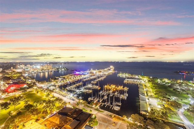 aerial view at dusk featuring a water view