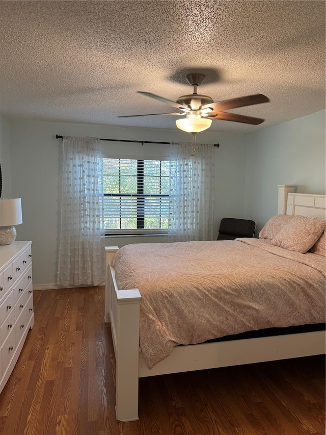 bedroom with dark wood-type flooring, a textured ceiling, and ceiling fan