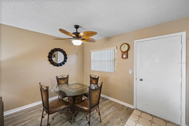 dining area with ceiling fan, hardwood / wood-style flooring, and a textured ceiling