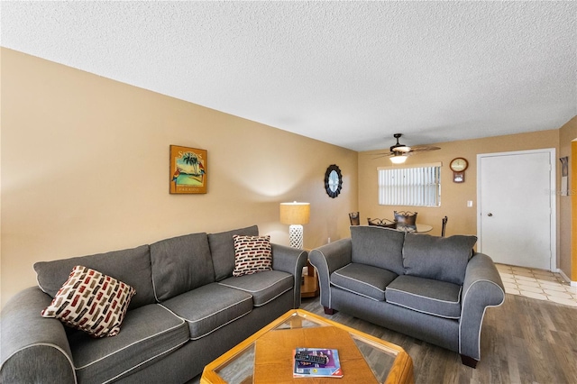 living room with ceiling fan, wood-type flooring, and a textured ceiling