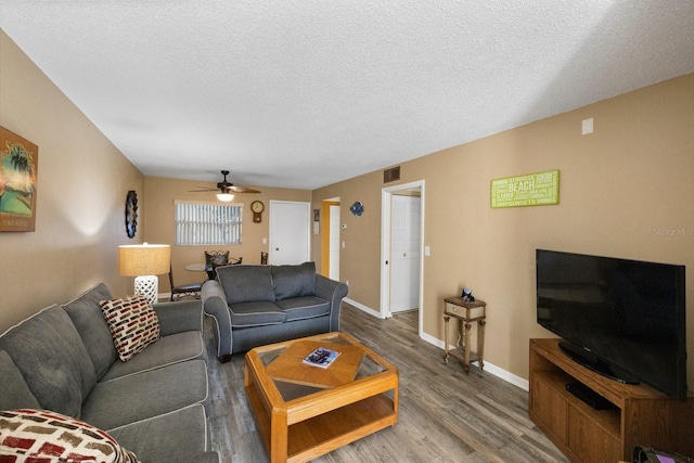 living room with hardwood / wood-style floors, a textured ceiling, and ceiling fan