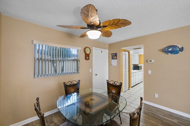 dining room featuring hardwood / wood-style floors, a textured ceiling, and ceiling fan