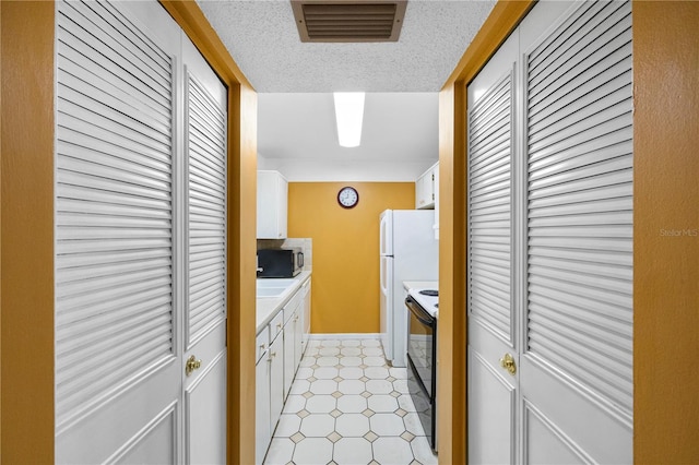 kitchen with black electric range oven and white cabinets