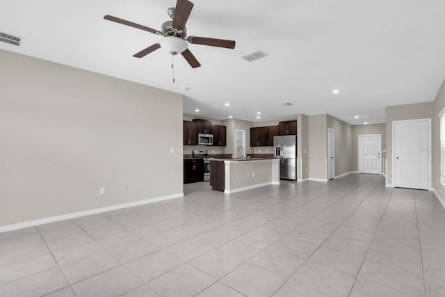 unfurnished living room with ceiling fan, sink, and light tile patterned floors