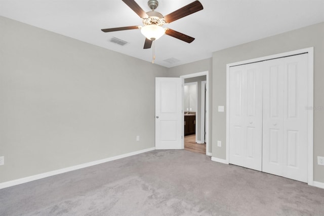 unfurnished bedroom featuring light colored carpet, a closet, and ceiling fan