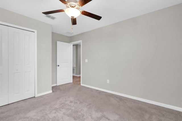 unfurnished bedroom featuring a closet, ceiling fan, and light carpet