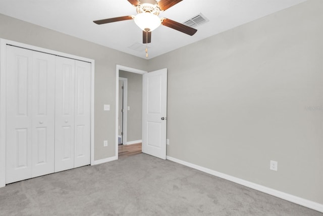 unfurnished bedroom featuring light colored carpet, a closet, and ceiling fan