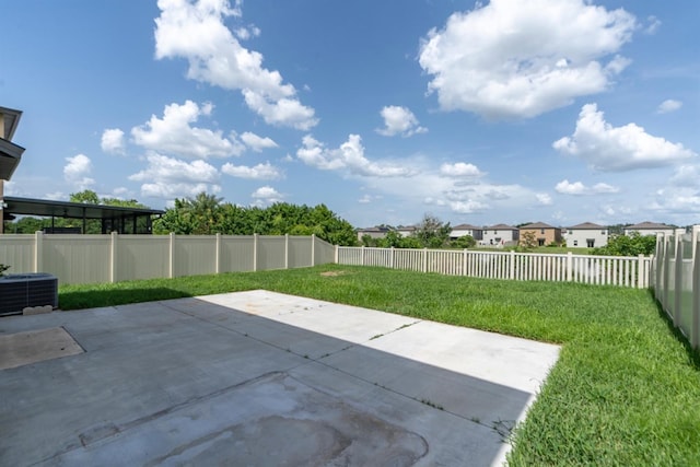 view of yard with central air condition unit and a patio