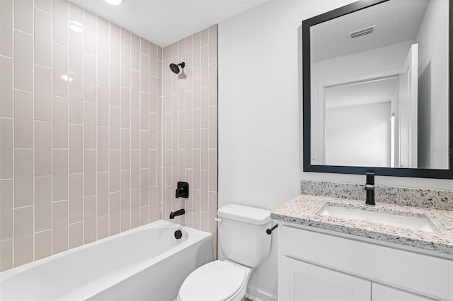 full bathroom with vanity, toilet, tiled shower / bath combo, and a textured ceiling