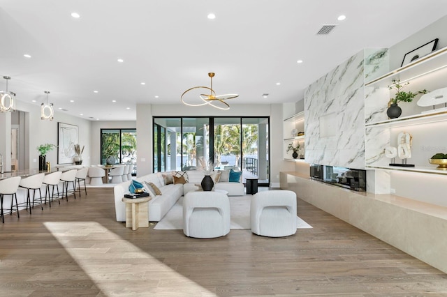 living room with a notable chandelier and light wood-type flooring