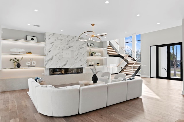 living room featuring light hardwood / wood-style flooring, a fireplace, and an inviting chandelier