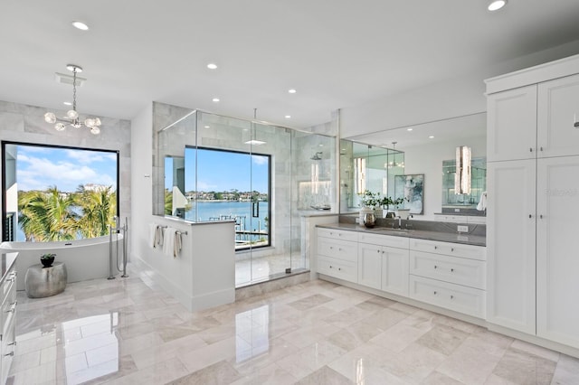 bathroom featuring a water view, plenty of natural light, shower with separate bathtub, and vanity