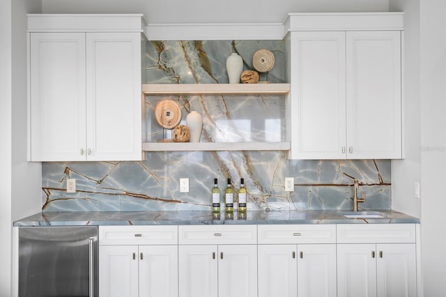 kitchen with sink, white cabinets, and refrigerator