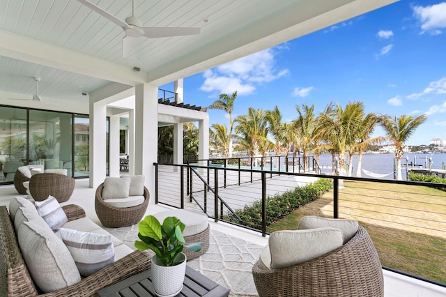 balcony featuring an outdoor living space, ceiling fan, and a water view