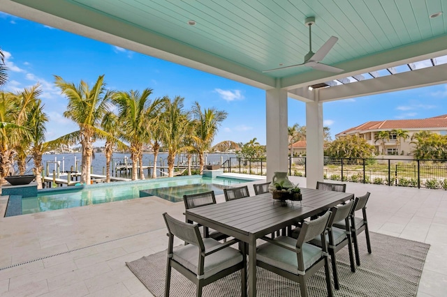 view of patio / terrace featuring a water view, ceiling fan, and a fenced in pool