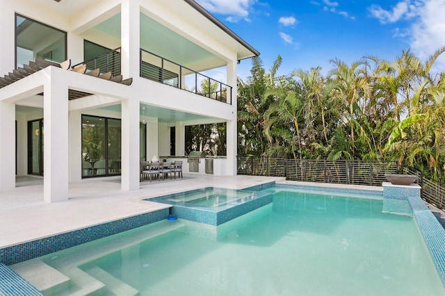 view of swimming pool with a patio area, exterior kitchen, and an in ground hot tub