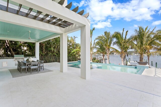 view of swimming pool with a patio, an outdoor kitchen, and area for grilling