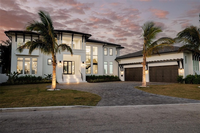 view of front of home with a garage and a yard