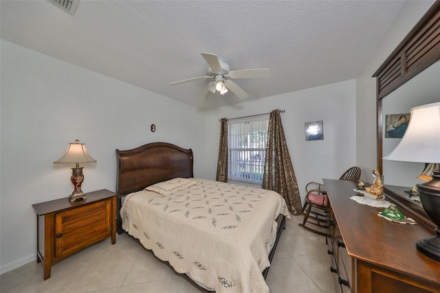 bedroom featuring a textured ceiling, light tile patterned floors, and ceiling fan